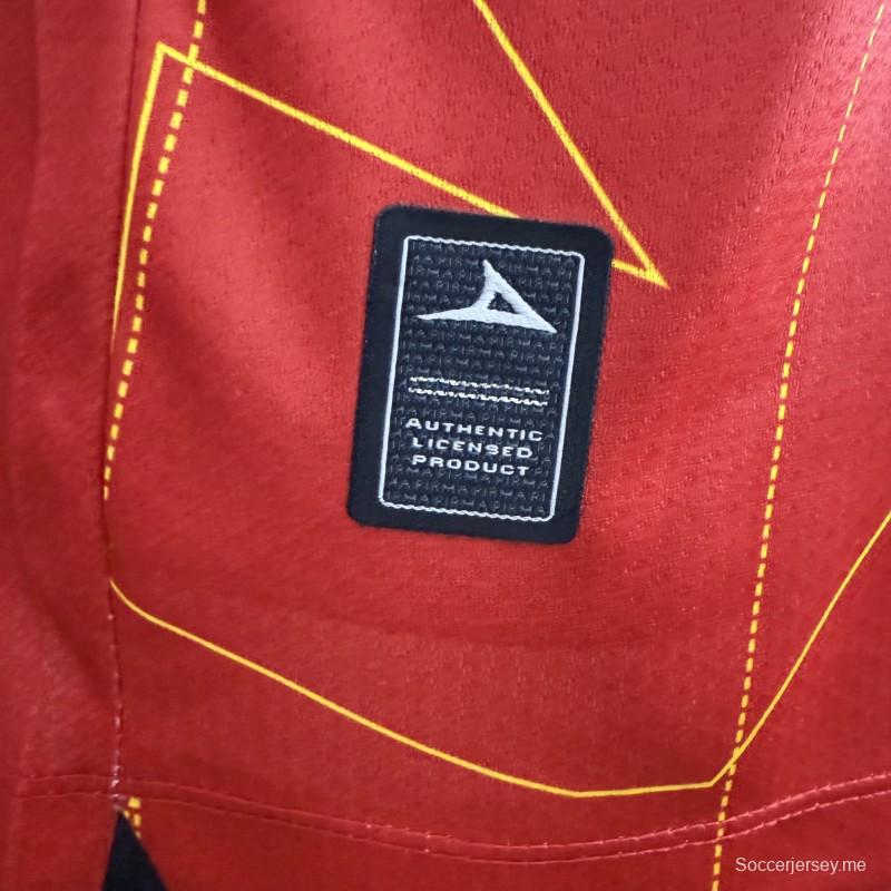 قميص اللاعب رقم 25/26 للنادي نيكاكسا (خارج أرضه) باللون الأحمر مع نقوش هندسية ذهبية على شكل صواعق