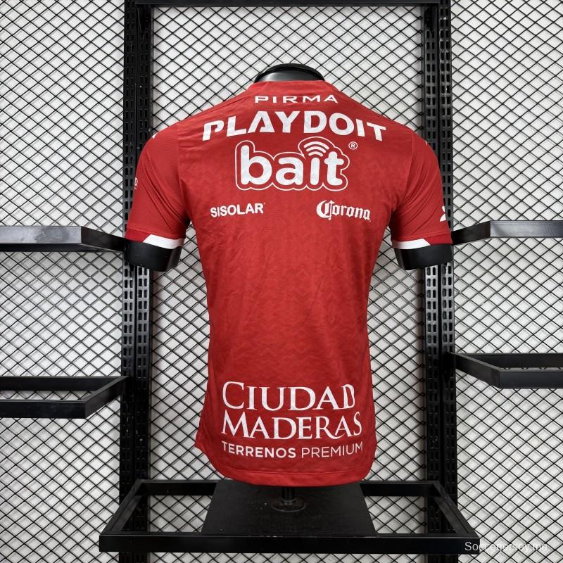 قميص اللاعب رقم 25/26 للنادي نيكاكسا (خارج أرضه) باللون الأحمر مع نقوش هندسية ذهبية على شكل صواعق