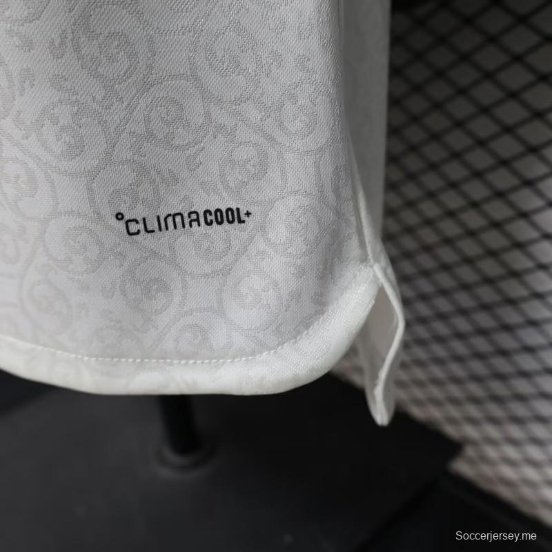 قميص اللاعب خارج أرض الملعب، إصدار 2026، إسبانيا — أبيض مع تفاصيل باللون العنابي والذهبي