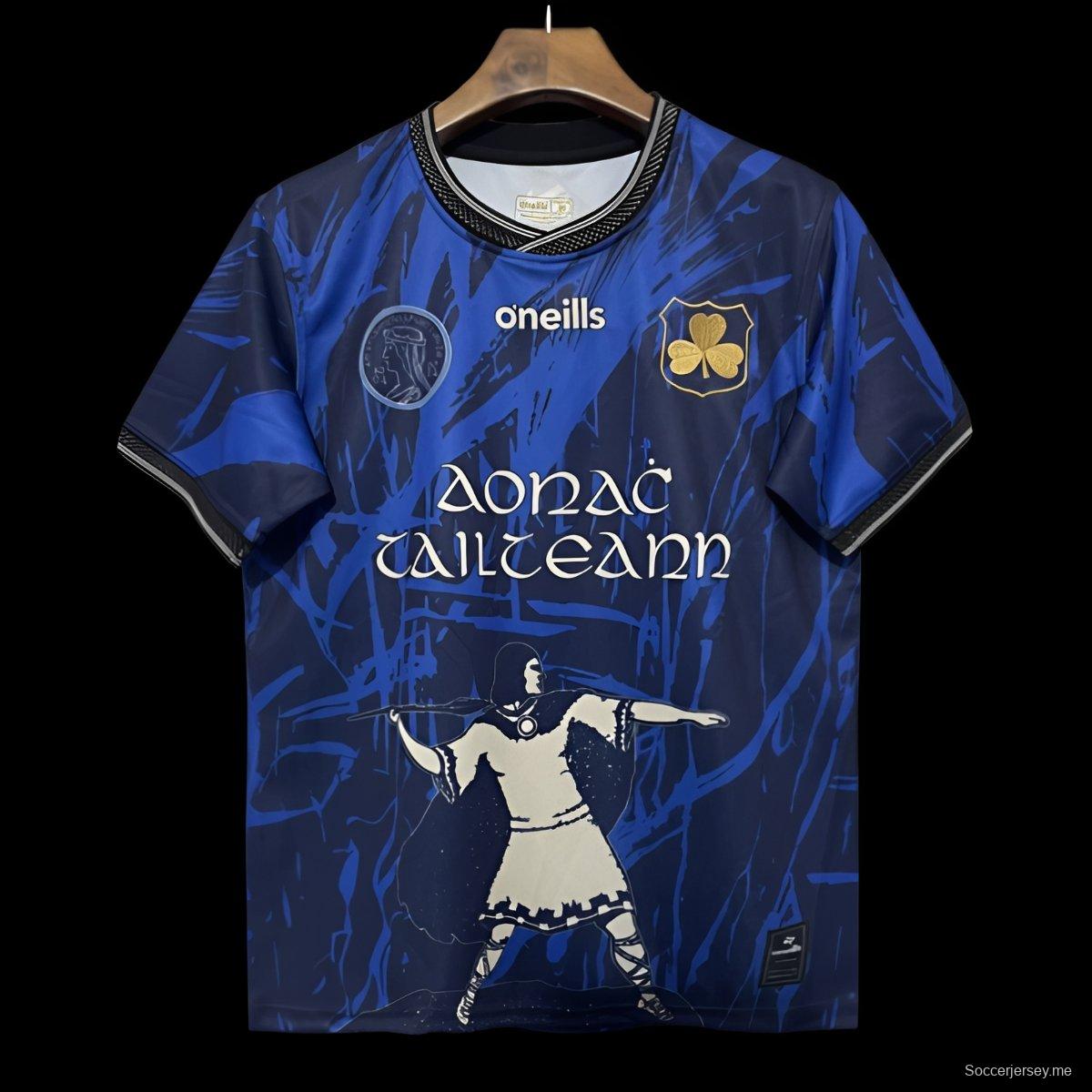 25/26 قميص تيبيراري GAA أزرق مع صورة ظلية للمحارب ونقشة مجردة