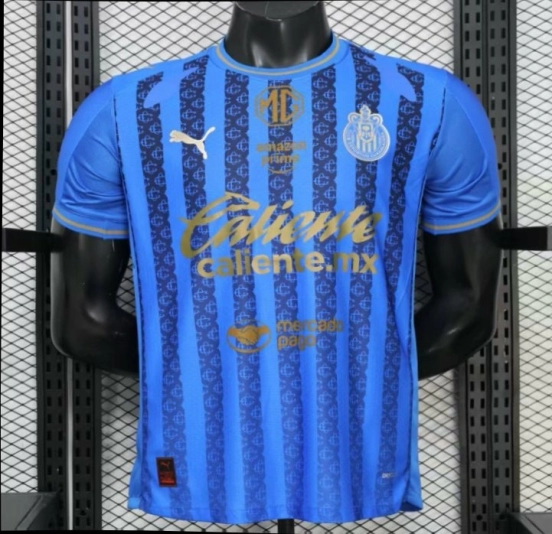قميص اللاعب رقم 26/27 لفريق تشيفاس غوادالاخارا (قميص خارجي أزرق بنمط خطوط داكنة)